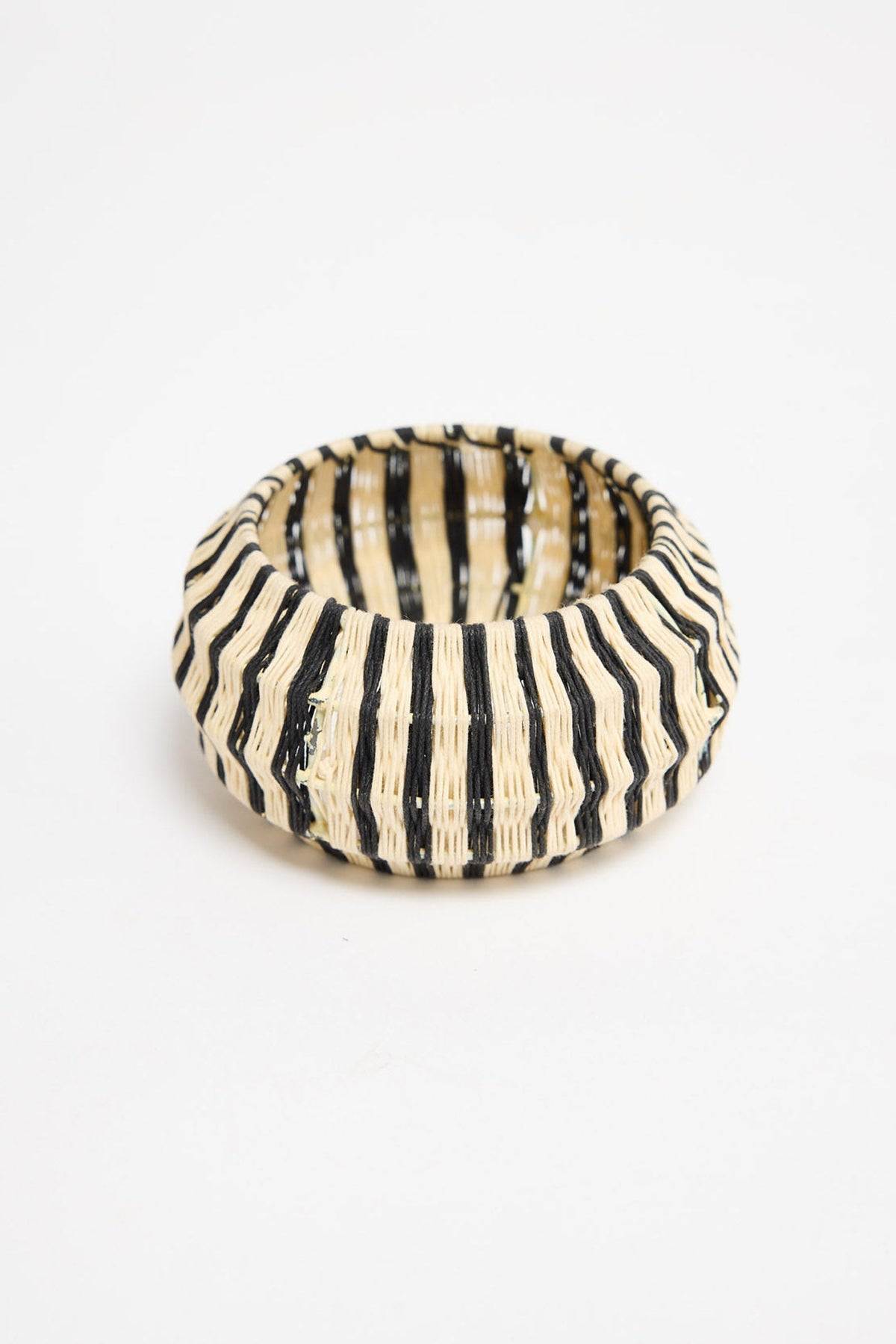 Top-down view of the Lancer Bangle in Stripe showing the woven cotton thread stripe pattern and rounded silhouette