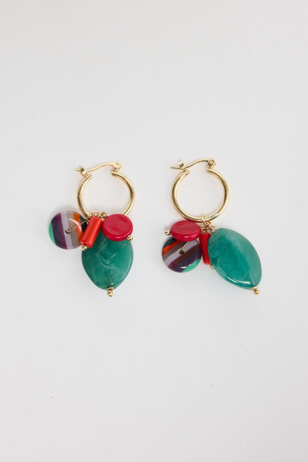 Pair of Elias drop earrings laid flat, showing gold-tone hoops with a green resin bead, red accents and a striped multicolour charm