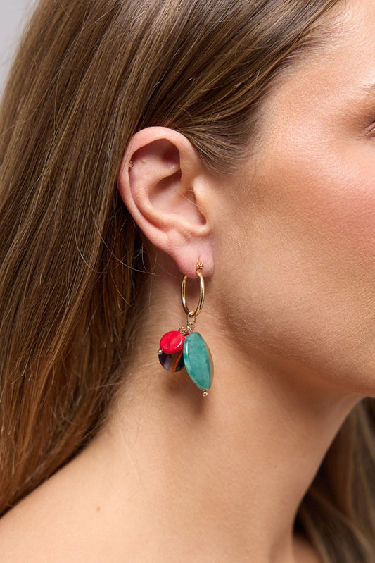 Close-up of the Elias Earrings in Green worn on the ear, showing the mixed resin charm cluster