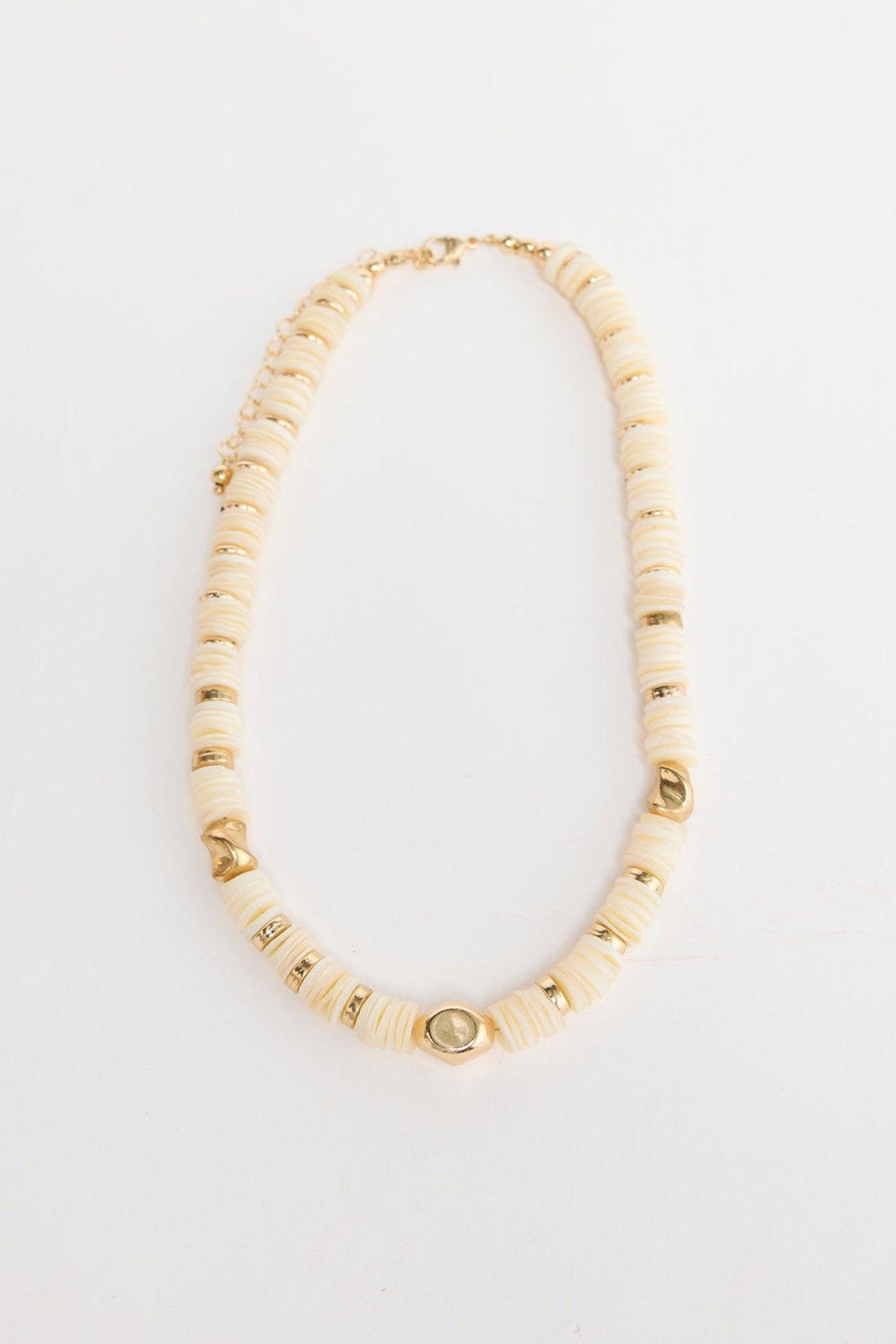Cassian beaded necklace laid flat, showing cream disc beads interspersed with polished gold-tone accent beads