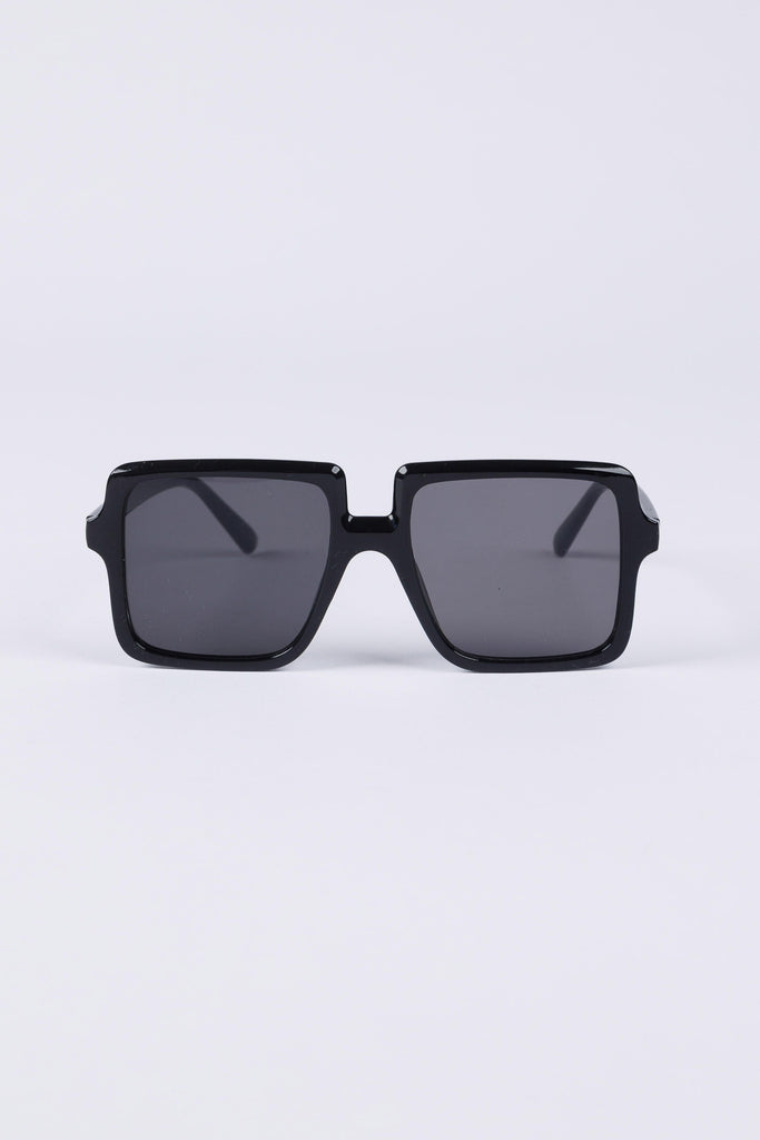 Black sunglasses with dark lenses on a light gray background