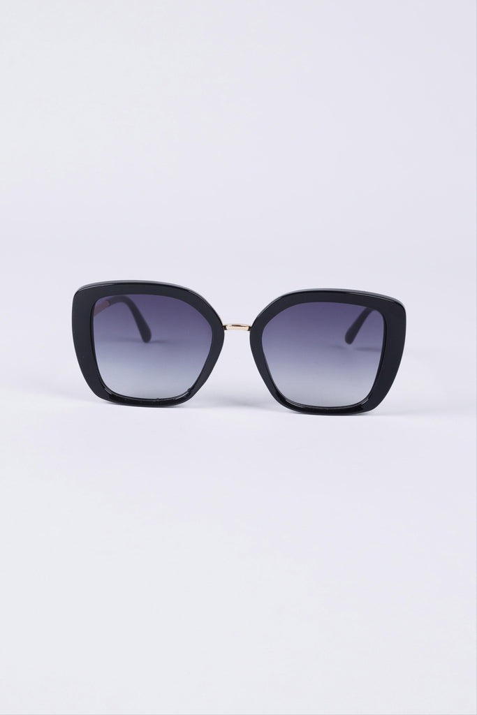 Black cat-eye sunglasses with gradient lenses on a light purple background
