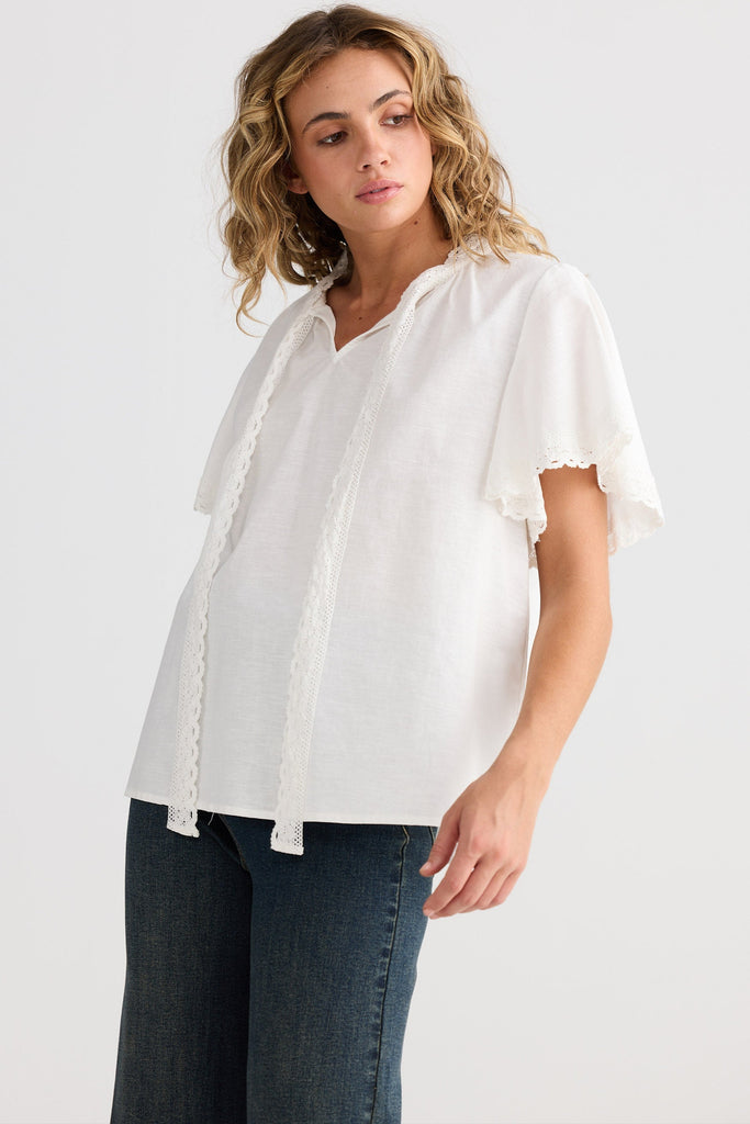 Woman wearing a white blouse and blue jeans on a white background