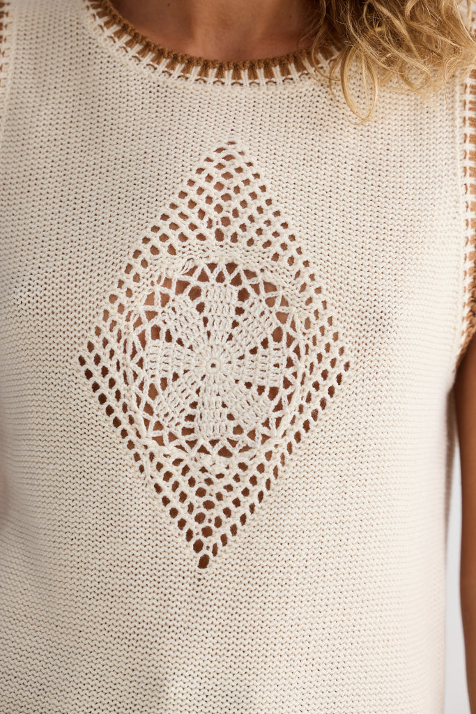 Beige sleeveless top with intricate lace pattern on a plain background