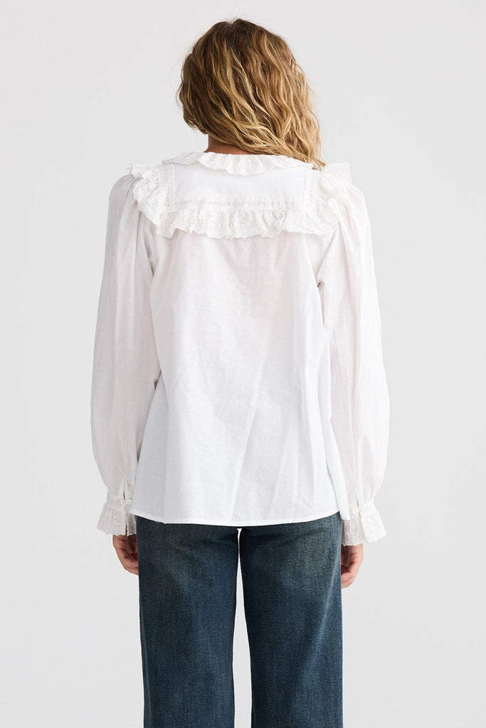 Person wearing a white blouse and blue jeans on a white background