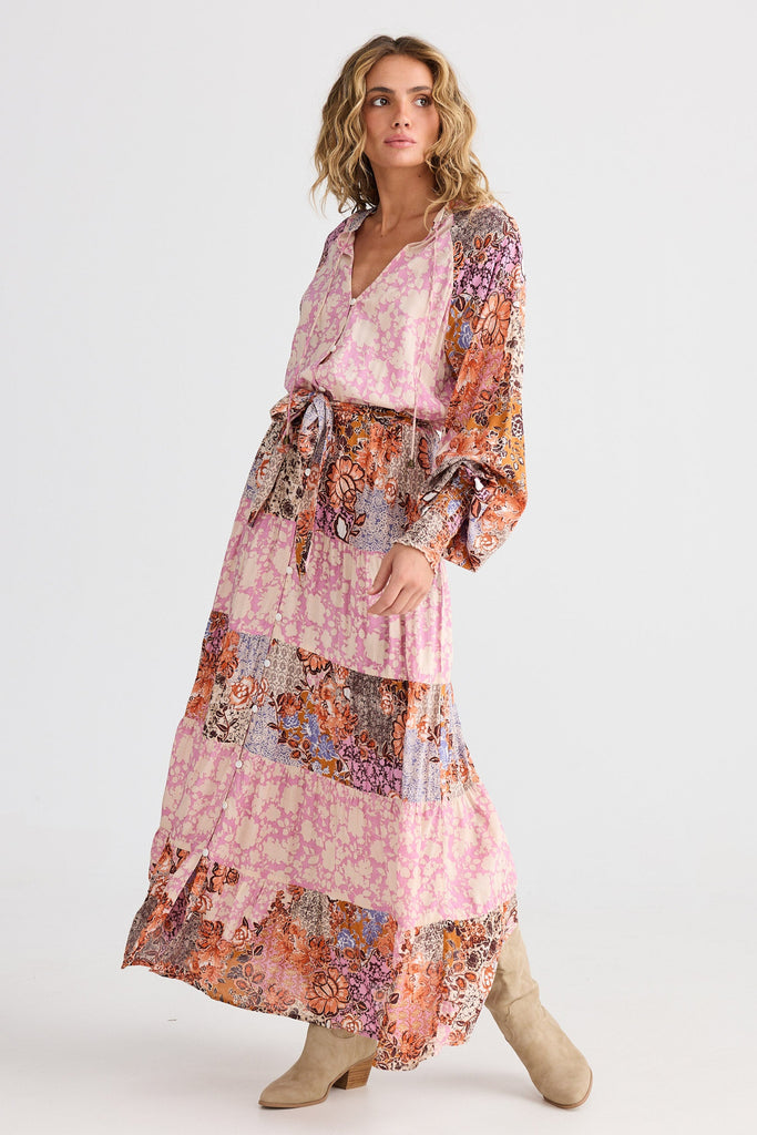 Woman wearing a long, patterned dress on a white background