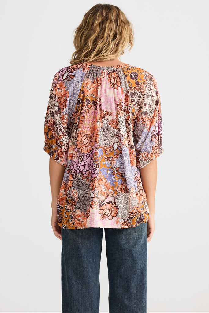 Woman wearing a floral blouse with a white background