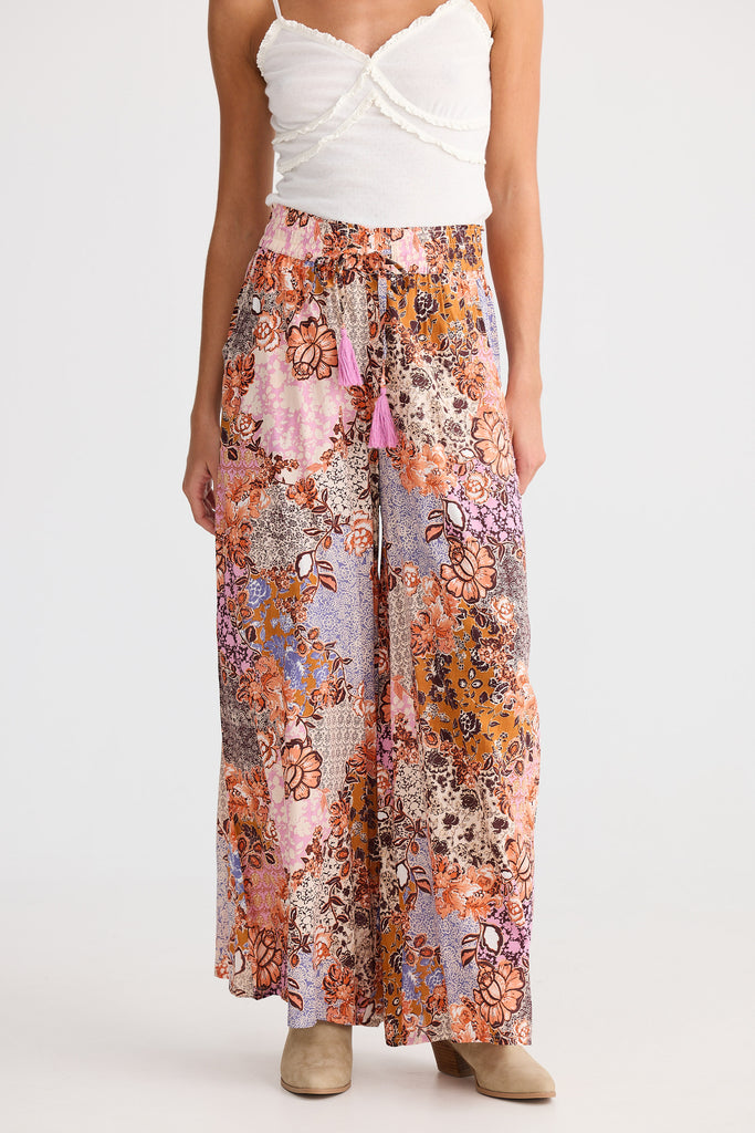 Woman wearing floral patterned pants on a white background