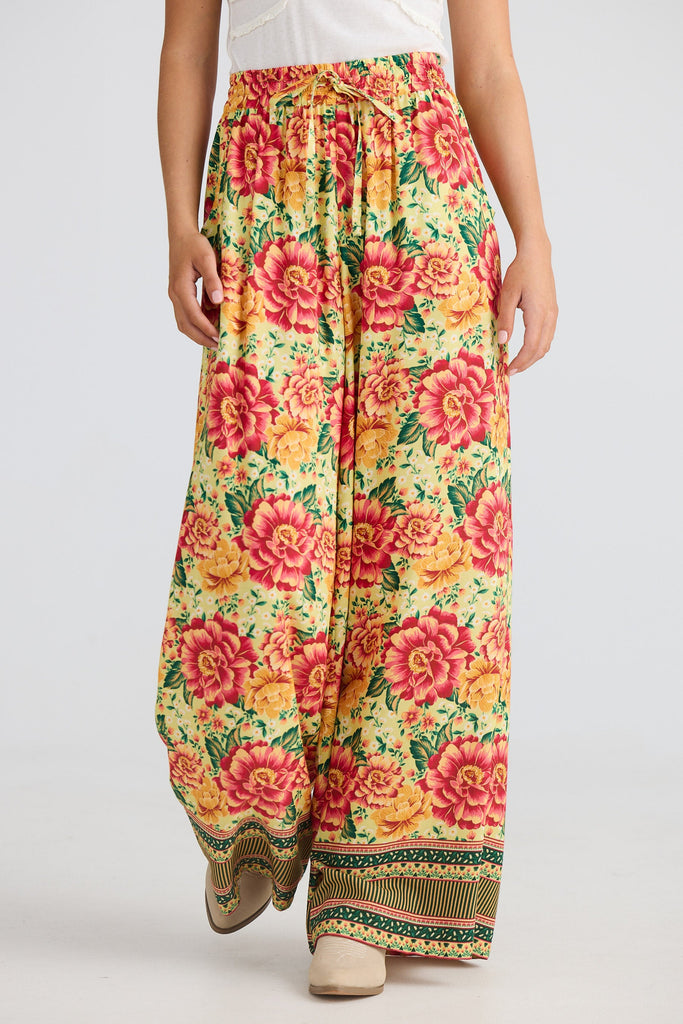 Floral patterned pants worn by a person on a plain background
