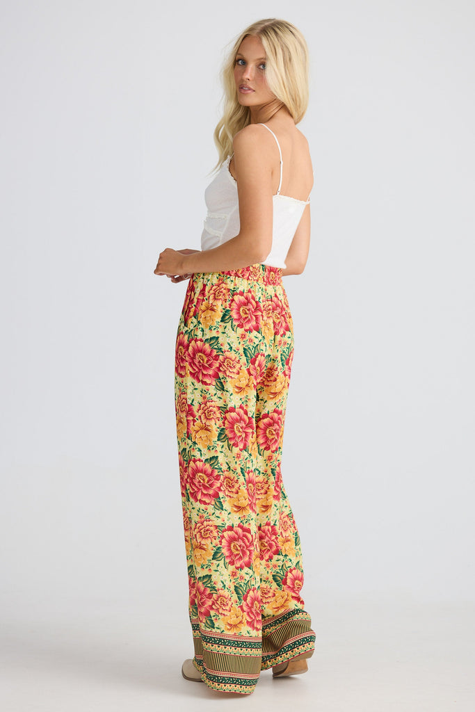 Woman wearing colorful floral pants on a white background