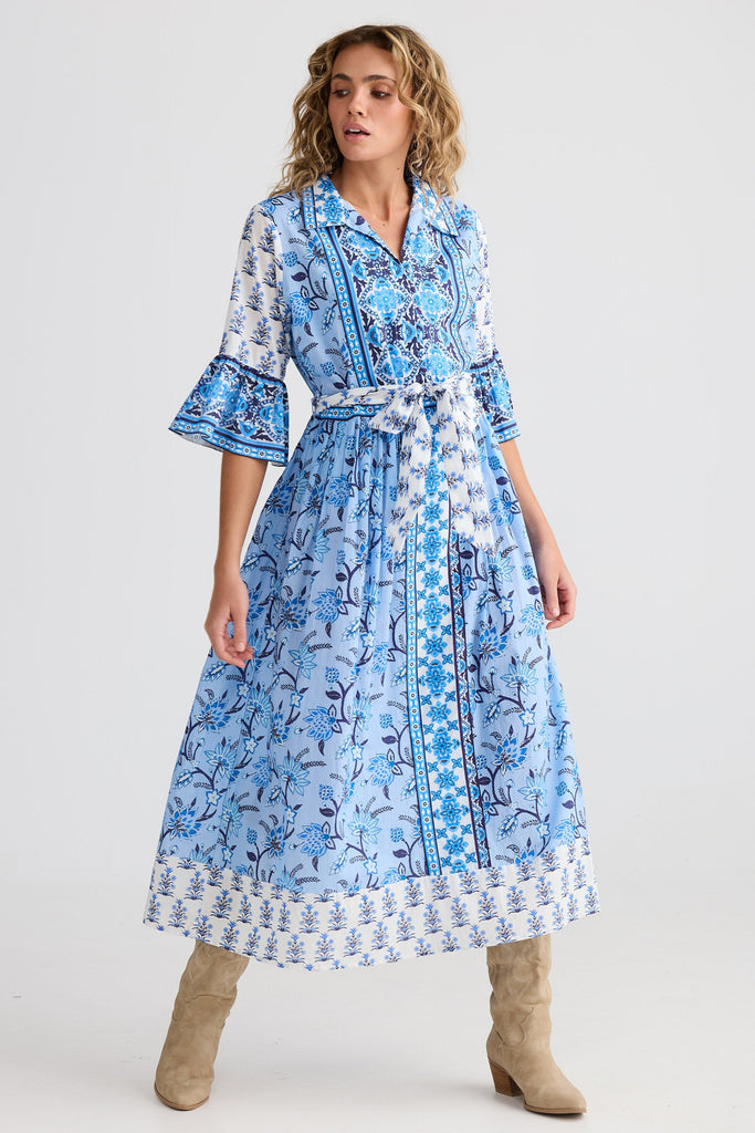 Woman wearing a blue patterned dress on a white background