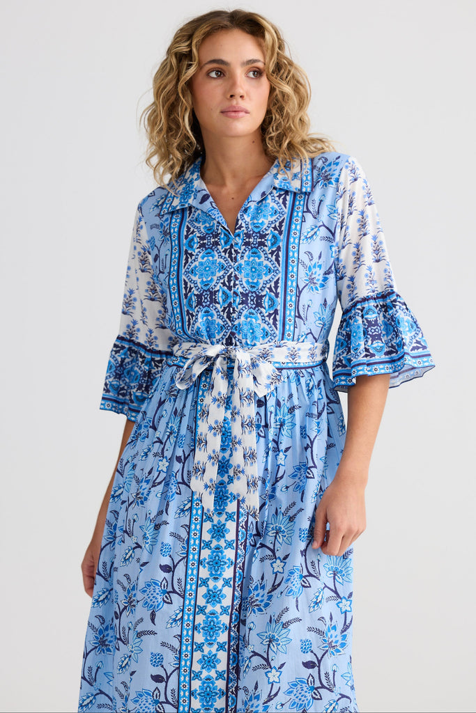 Woman wearing a blue patterned dress against a white background