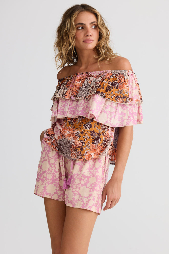 Woman wearing a colorful off-shoulder dress on a white background