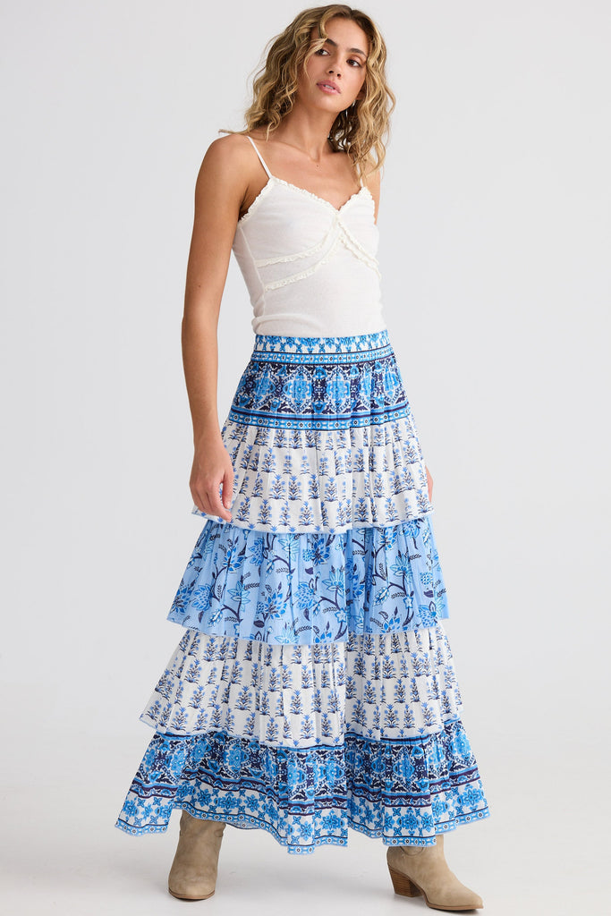 Woman wearing a blue and white patterned skirt on a white background