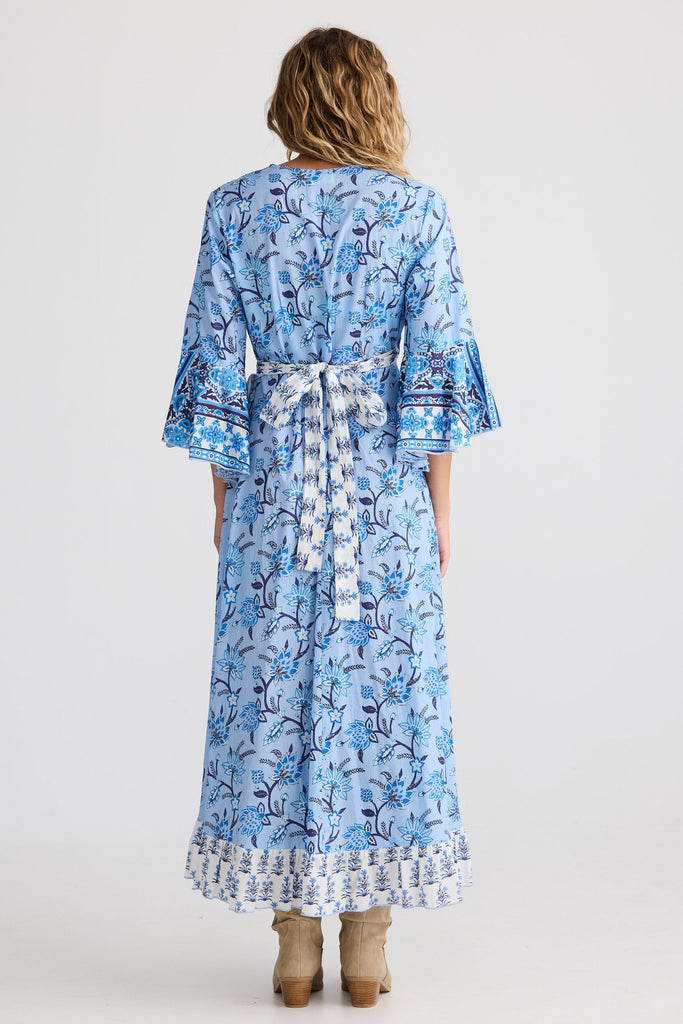 Woman wearing a blue floral dress on a white background