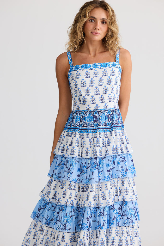 Woman wearing a blue and white patterned dress on a light gray background