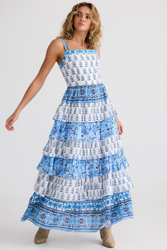 Woman wearing a blue and white patterned dress on a white background