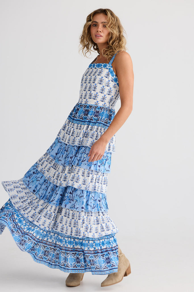 Woman wearing a blue and white patterned dress on a plain background