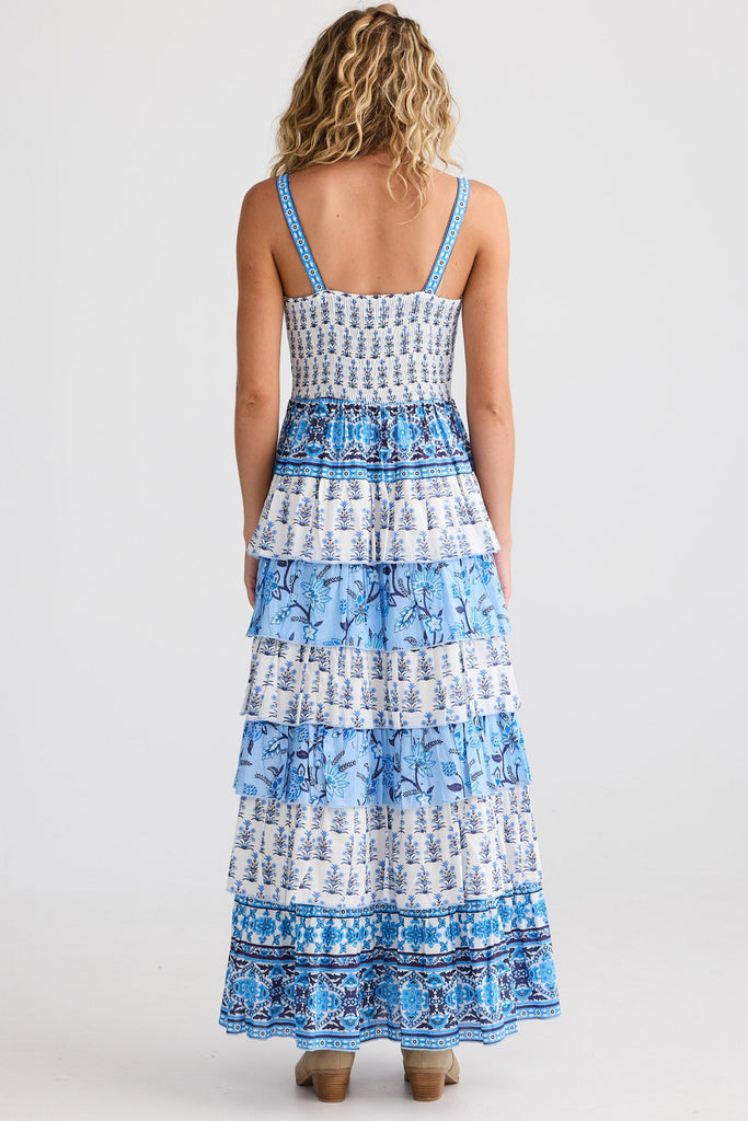 Woman wearing a blue and white patterned dress on a white background