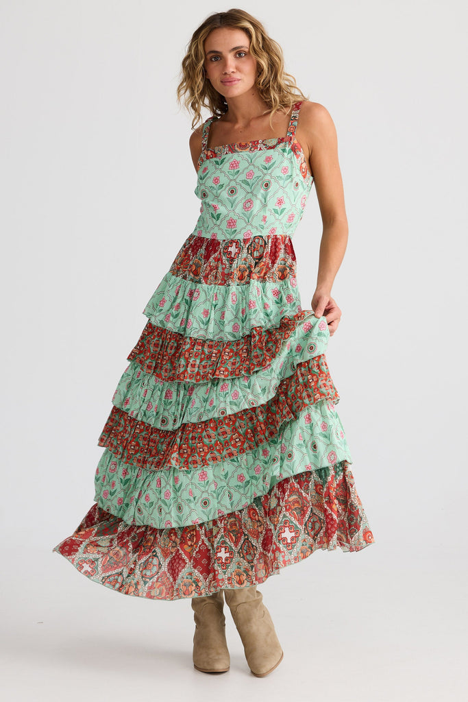 Woman wearing a tiered dress with a floral pattern on a white background
