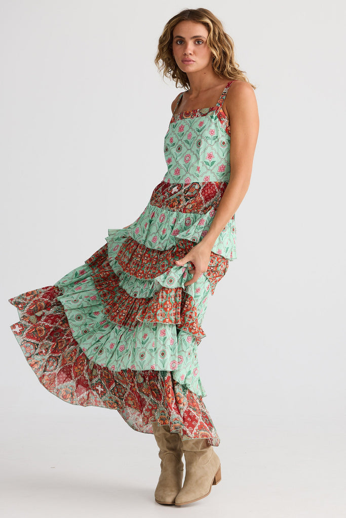 Woman wearing a patterned dress with ruffles on a white background