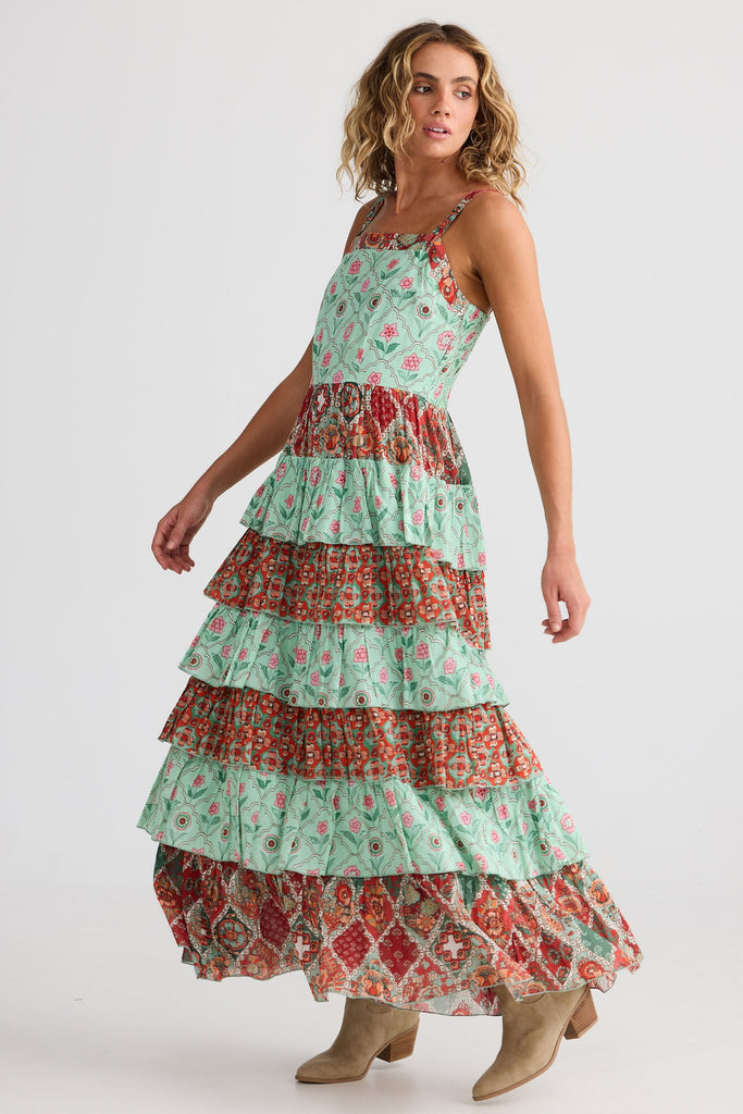 Woman wearing a tiered floral dress on a white background