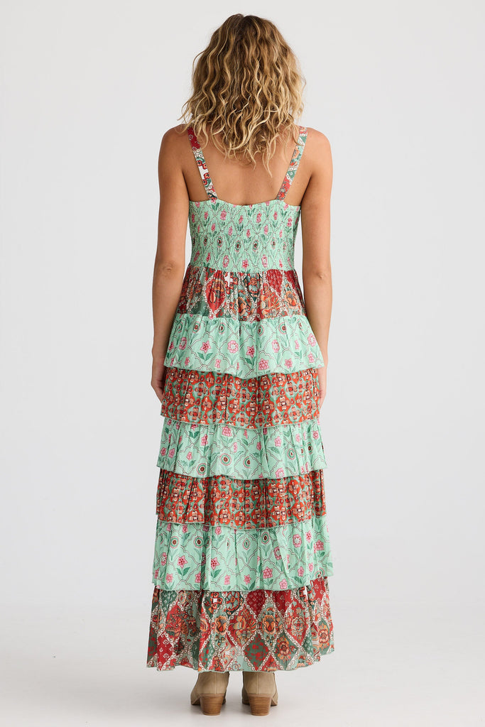 Woman wearing a tiered dress with a floral pattern on a white background