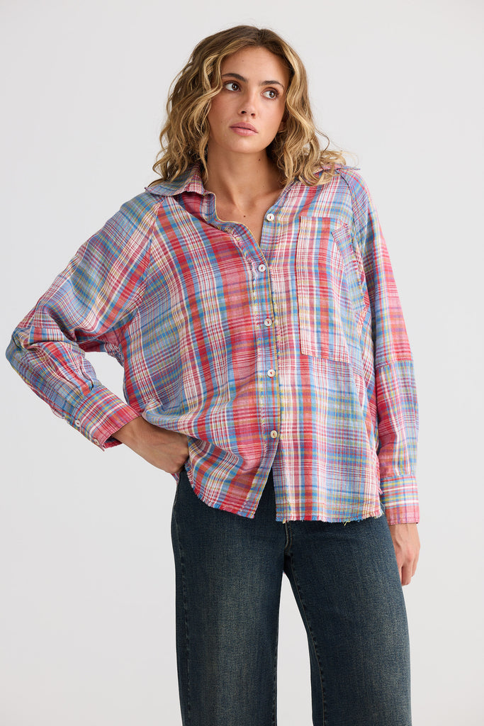Woman wearing a plaid shirt and jeans on a white background