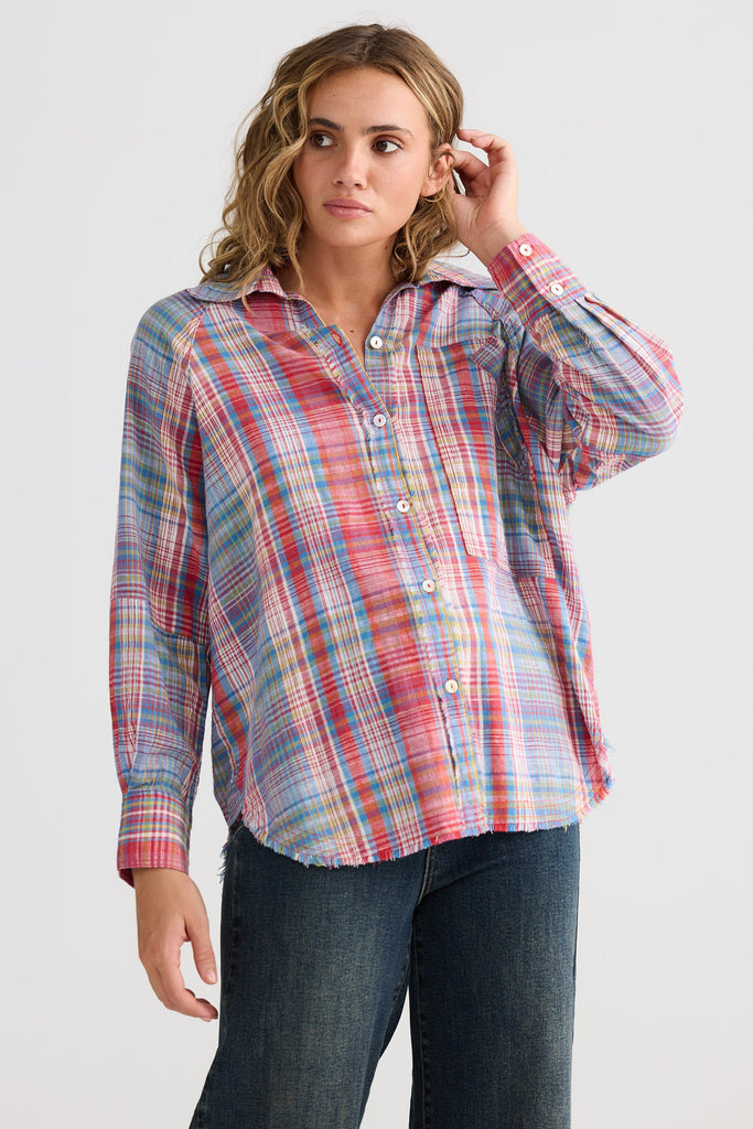 Woman wearing a plaid shirt and jeans on a white background