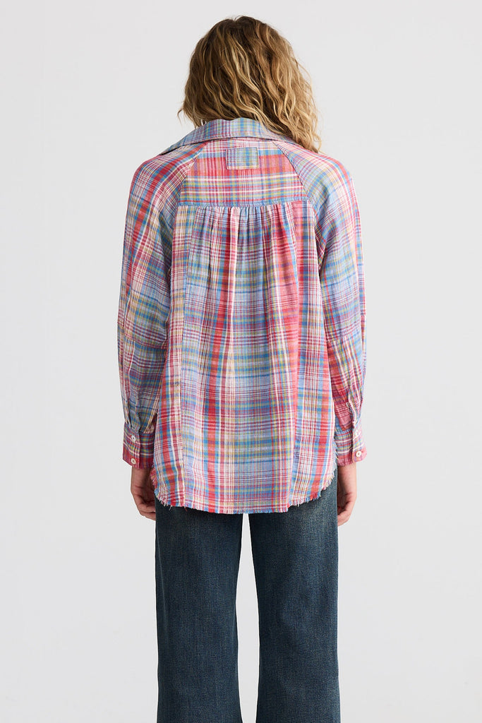 Person wearing a plaid shirt and jeans from behind on a white background