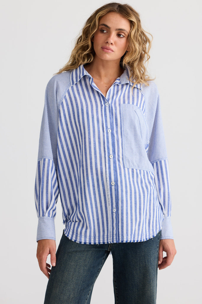 Woman wearing a blue and white striped shirt against a plain background