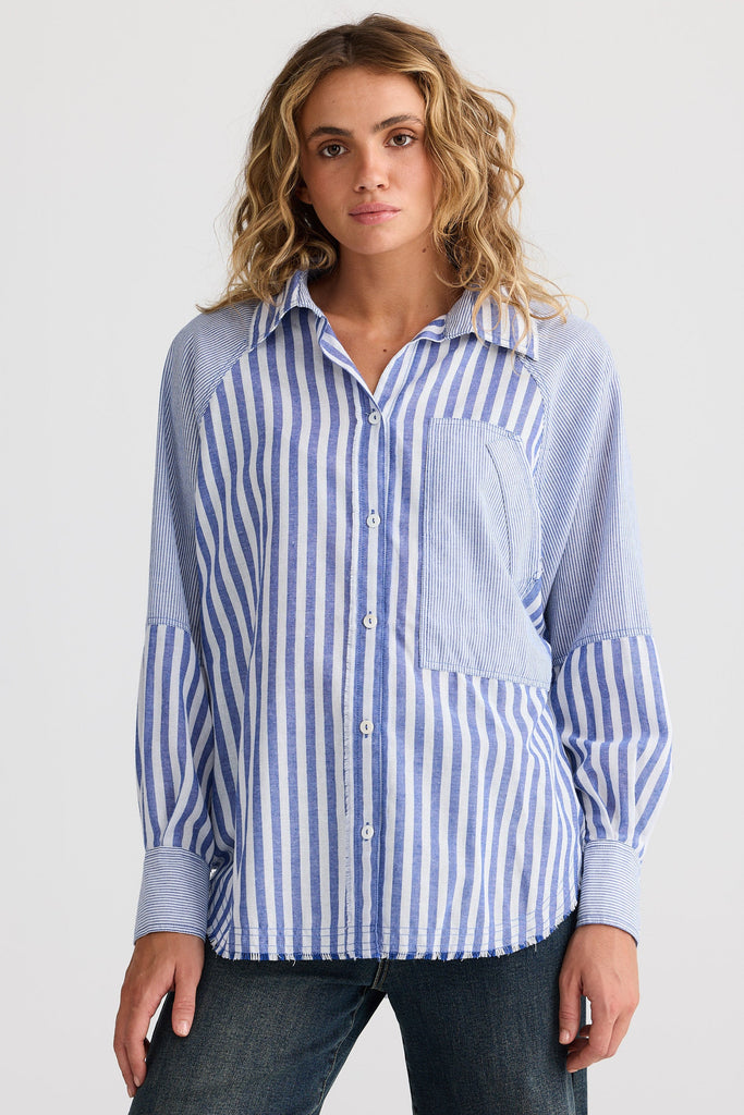 Woman wearing a blue and white striped shirt on a plain background