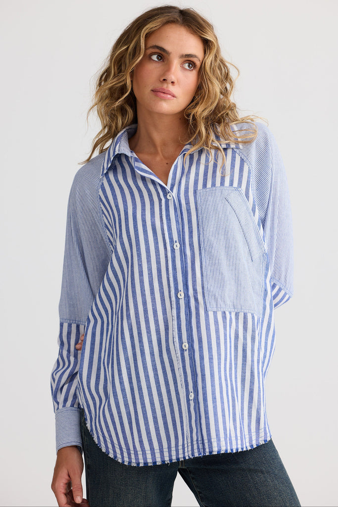 Woman wearing a blue and white striped shirt against a plain background