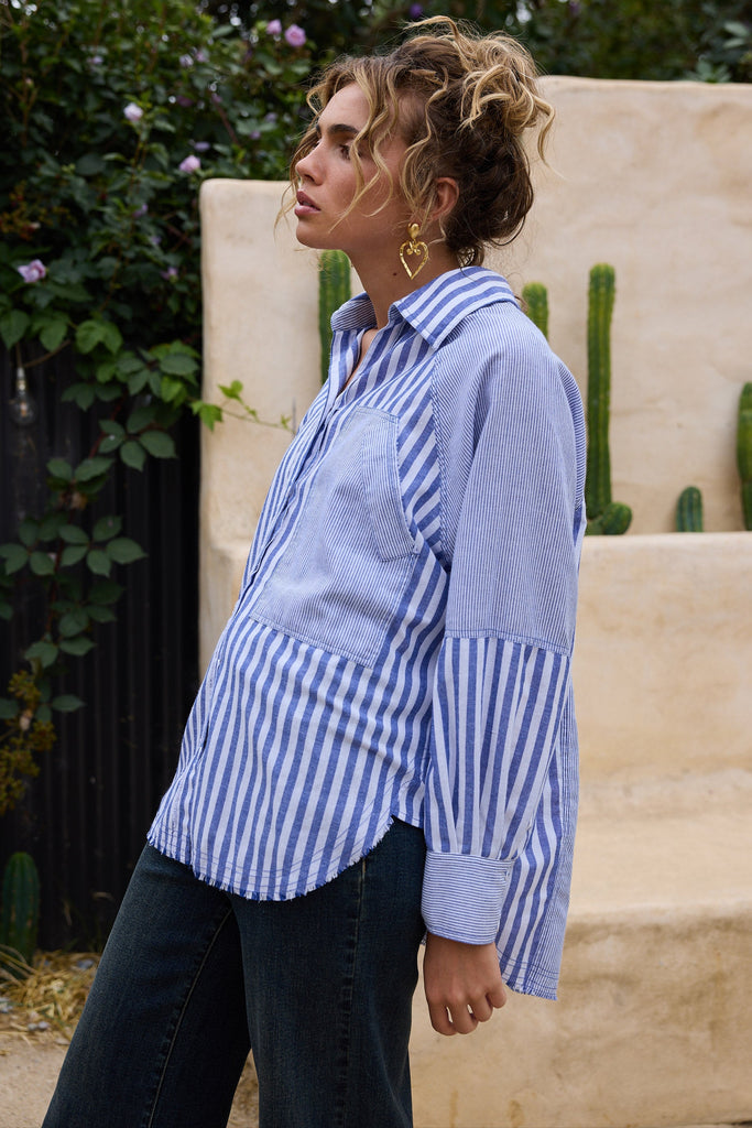 Woman wearing a blue and white striped shirt with a cactus in the background