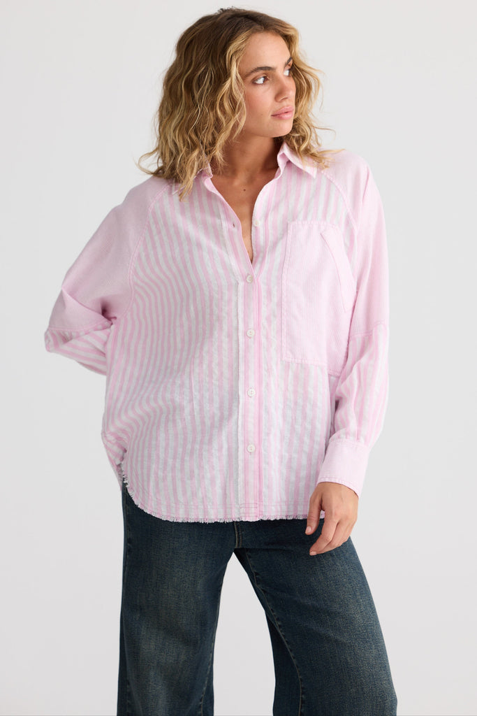 Woman wearing a pink striped shirt and jeans on a white background