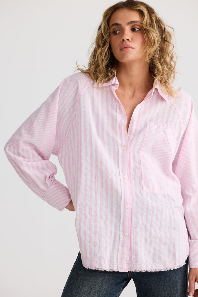 Woman wearing a pink striped shirt against a white background