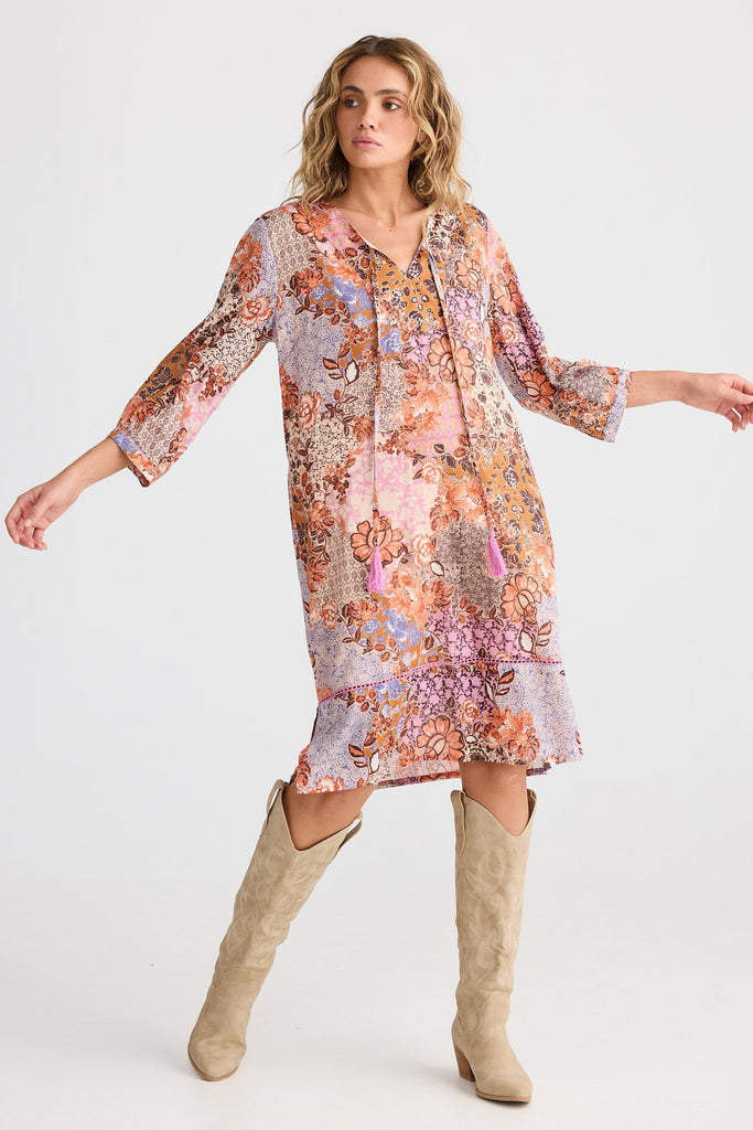 Woman wearing a floral dress with long sleeves on a white background