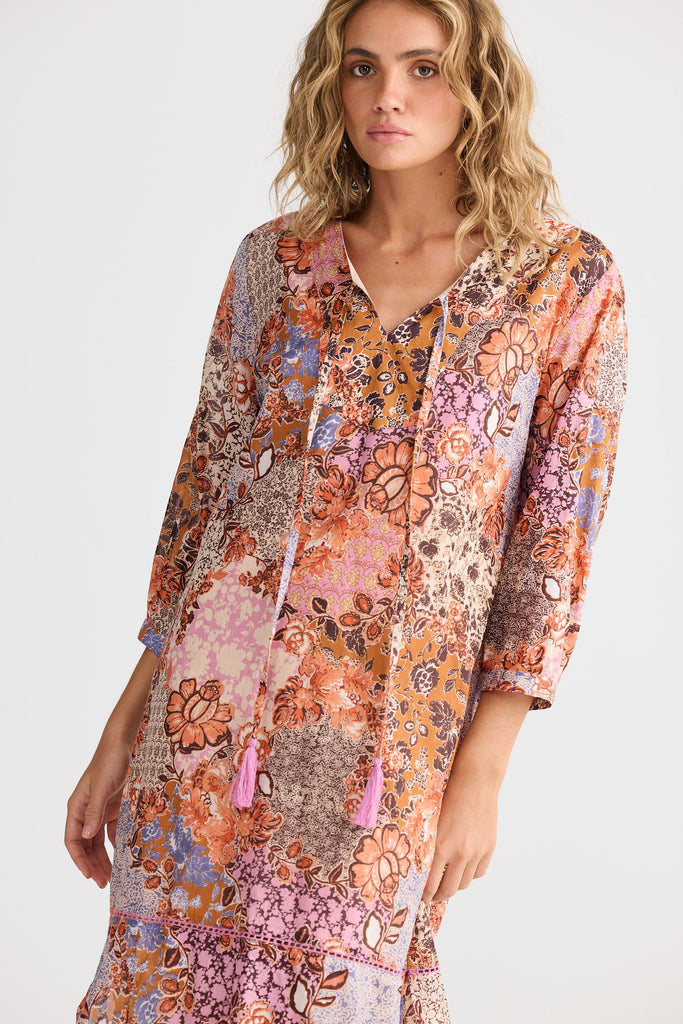 Woman wearing a colorful floral dress on a white background