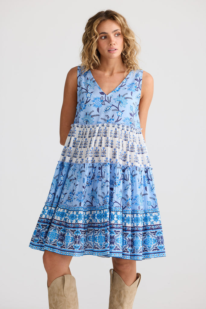 Woman wearing a blue patterned dress on a white background