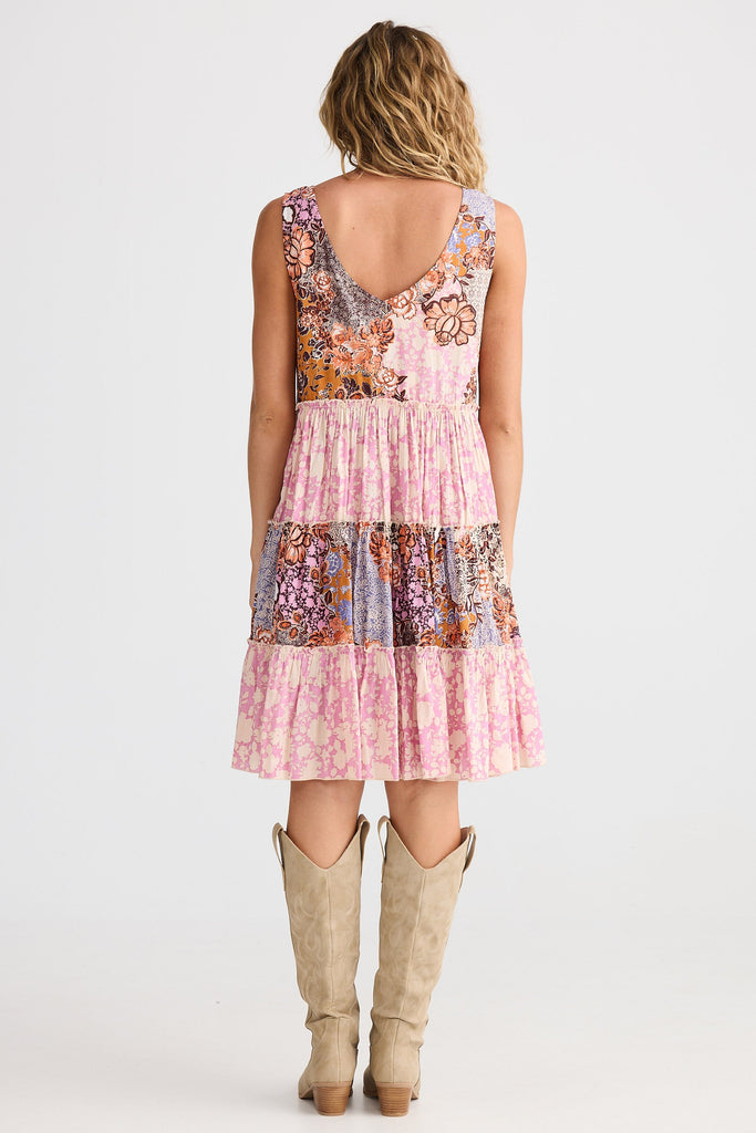 Woman wearing a patterned dress and boots on a white background