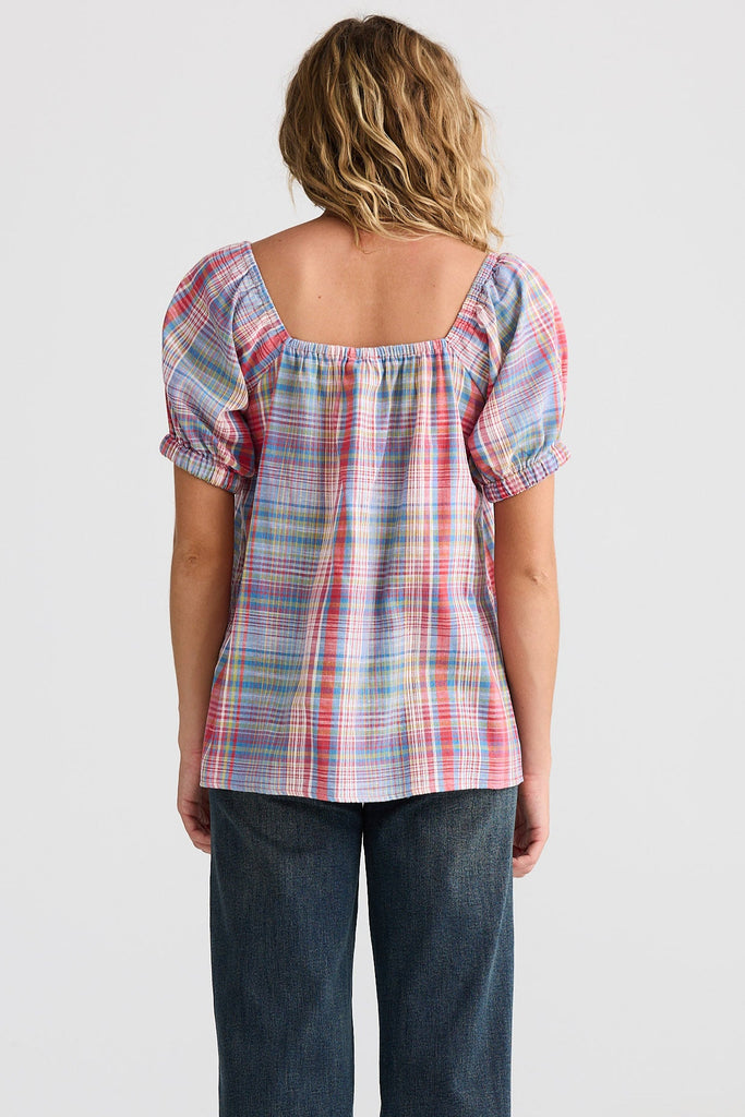 Person wearing a plaid top and jeans from behind on a white background