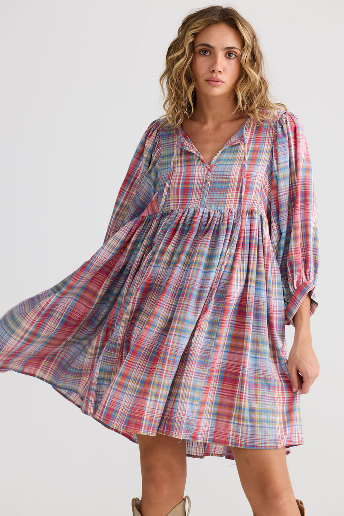 Woman wearing a plaid dress on a white background