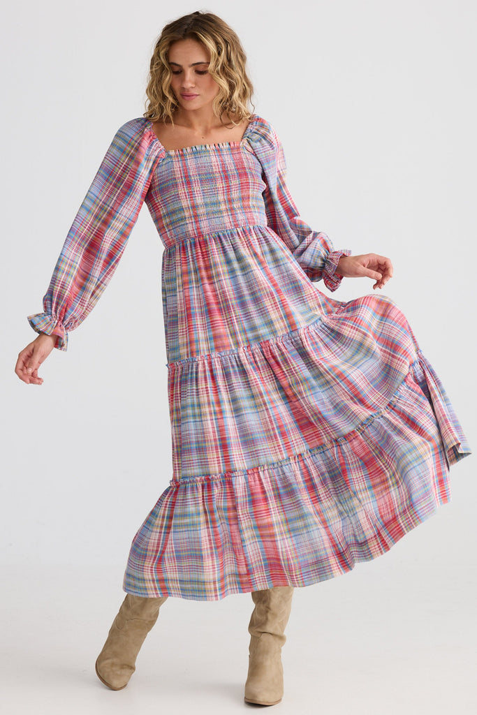 Woman wearing a plaid dress on a white background