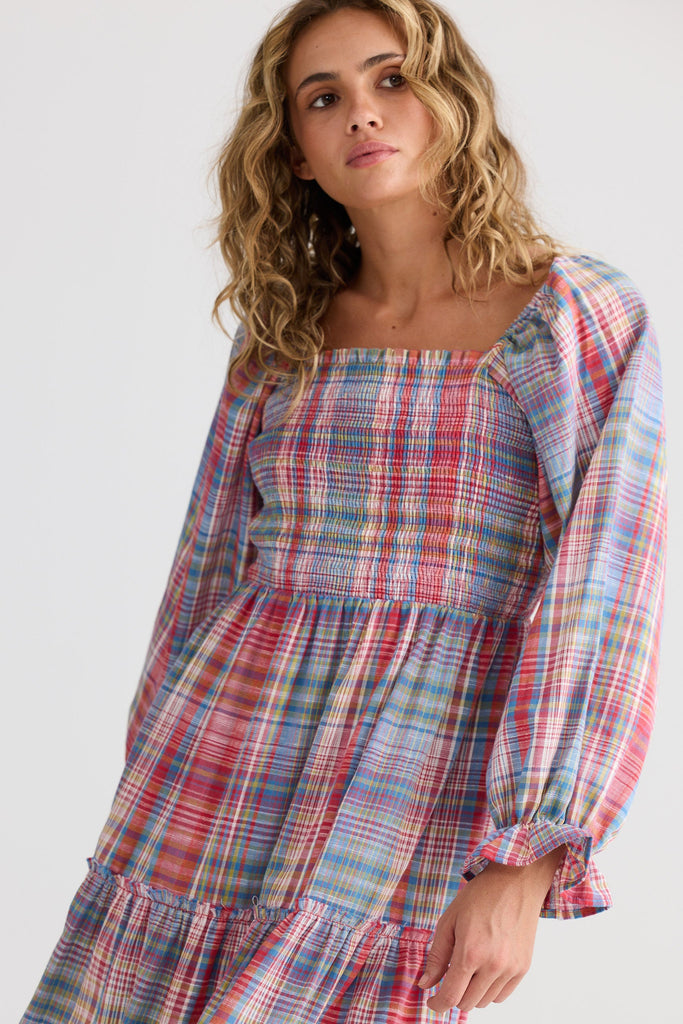 Woman wearing a plaid dress with a plain background