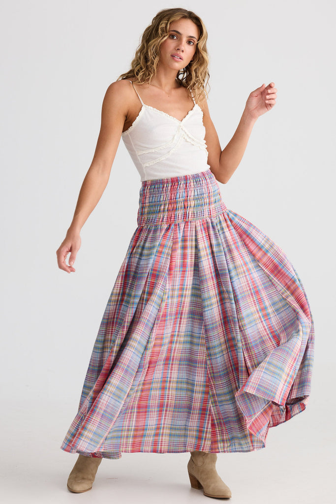 Woman wearing a white top and plaid skirt on a white background