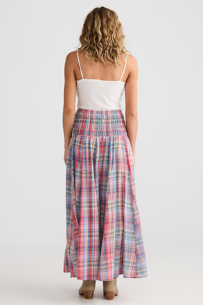 Woman wearing a white top and plaid skirt on a white background