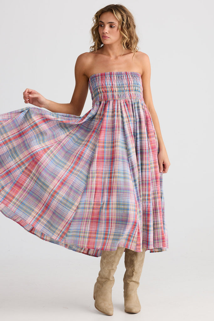 Woman wearing a plaid dress with a white background