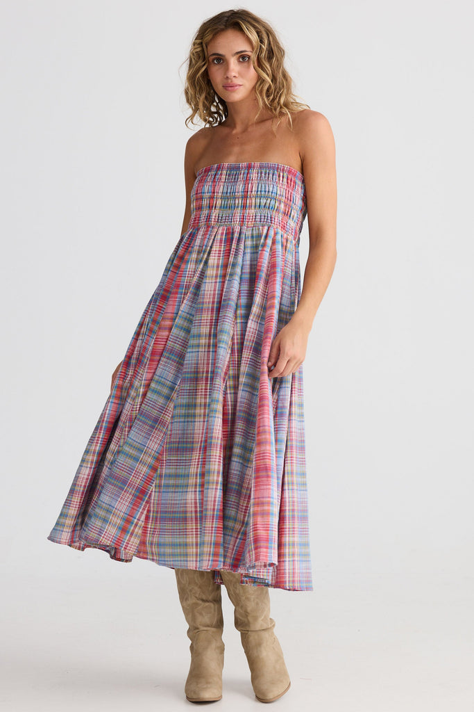 Woman wearing a plaid strapless dress on a white background