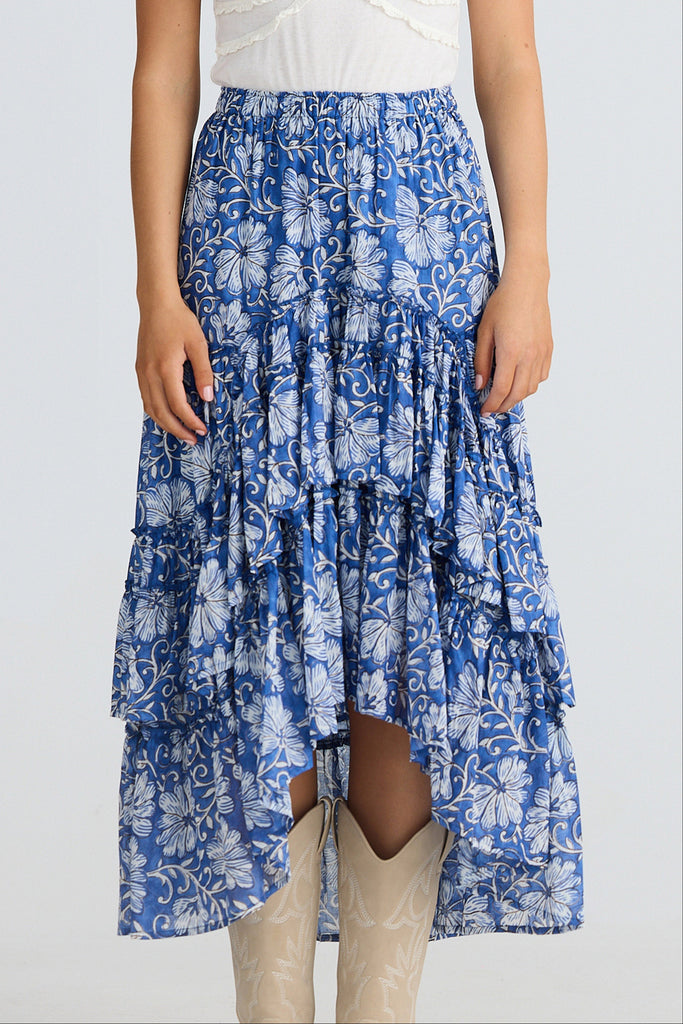 Blue floral tiered skirt worn by a person on a white background