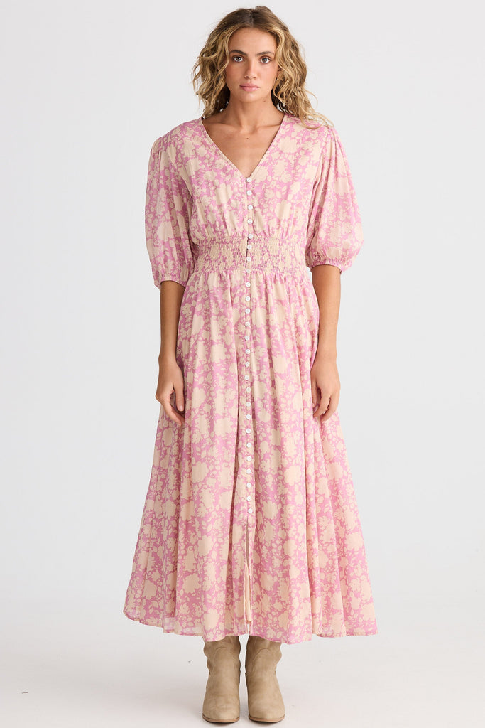 Woman wearing a pink floral dress on a white background
